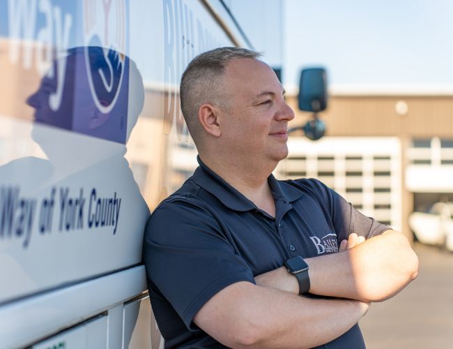 man leaning against bus