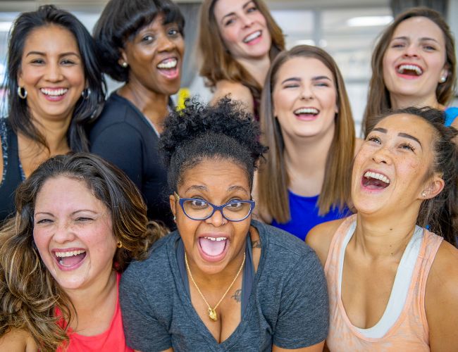 Eight women posing for a camera smiling.