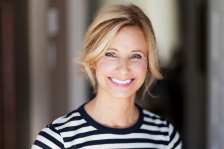 A woman wearing a black and white striped T-shirt smiling at the camera