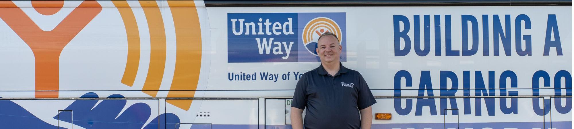 Man standing in front of the bus he drives