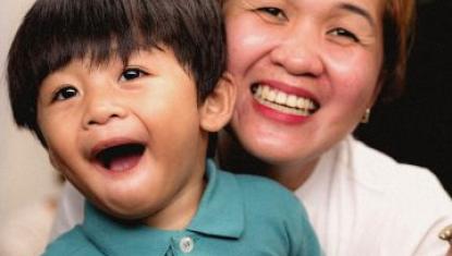 Grandmother holding her grandson smiling at the camera