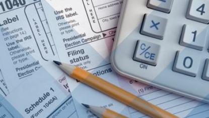 Tax paperwork, calculator, and pencils